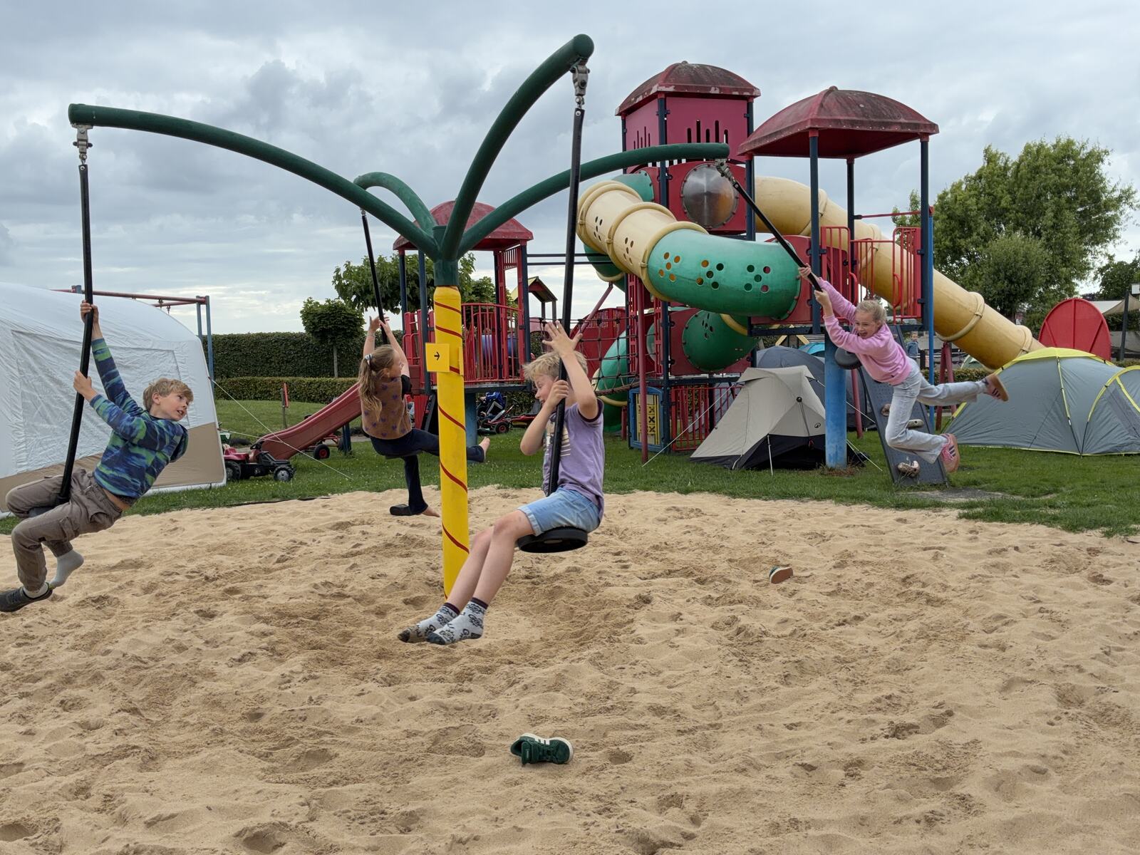 Kinderen spelen bij het klimtoestel in het zand