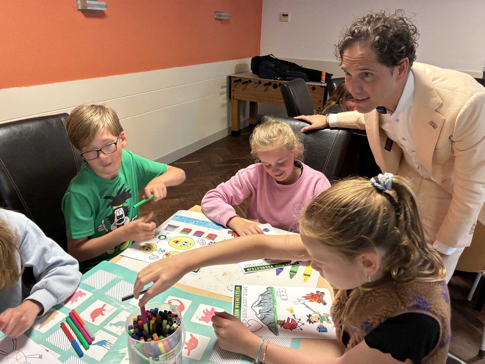 Kinderen kleuren tekeningen tijdens een knutselactiviteit