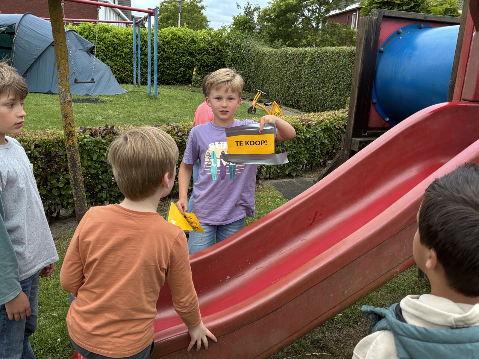 Kinderen bij de glijbaan tijdens een speeltuinactiviteit
