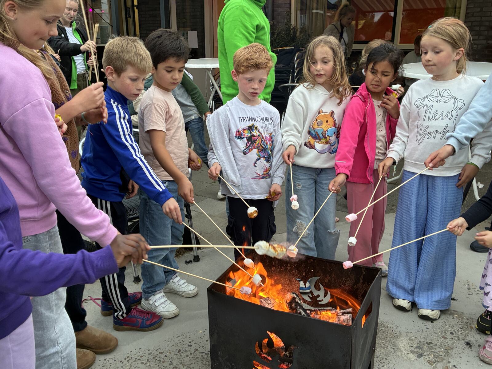 Kinderen roosteren marshmallows boven het vuur