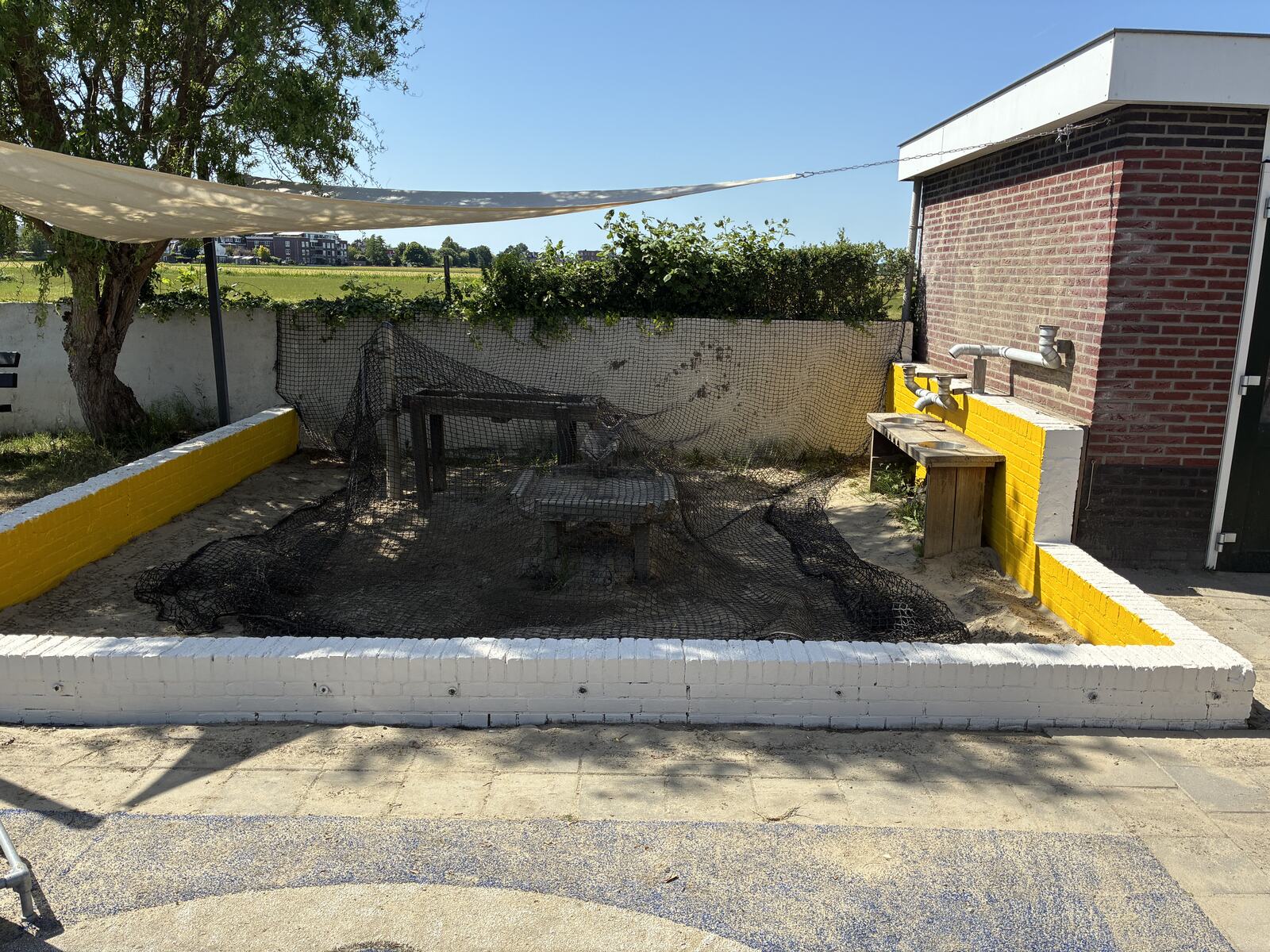 Zandtafel en watertap in de speeltuin op een zonnige dag