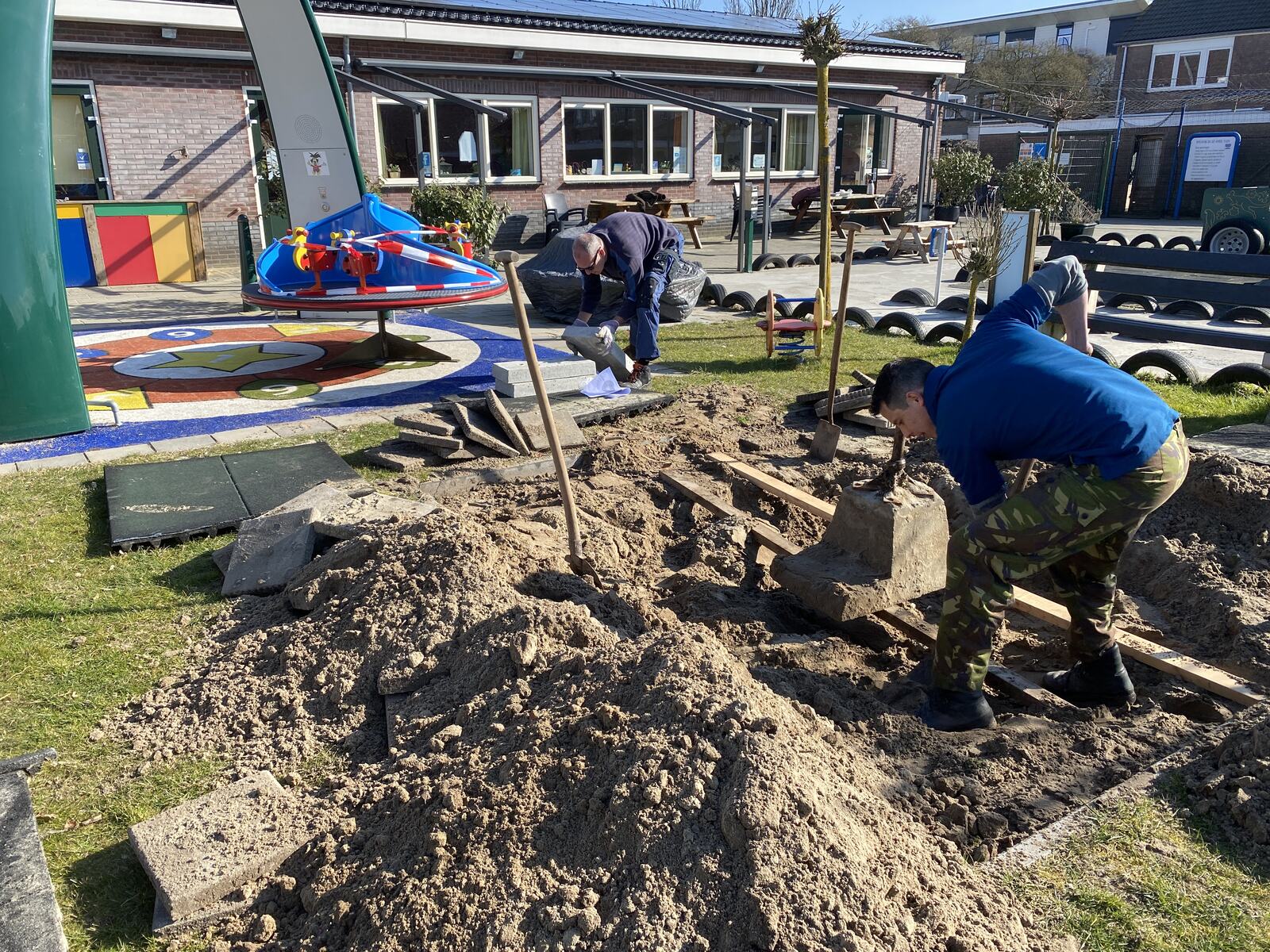 Vrijwilligers aan het werk bij de renovatie van de speeltuin