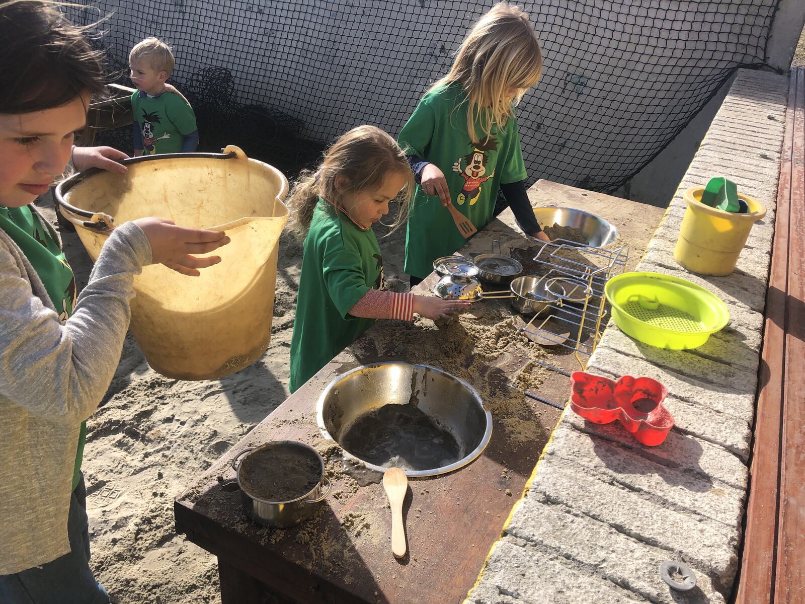 Kinderen spelen samen bij de zandkeuken