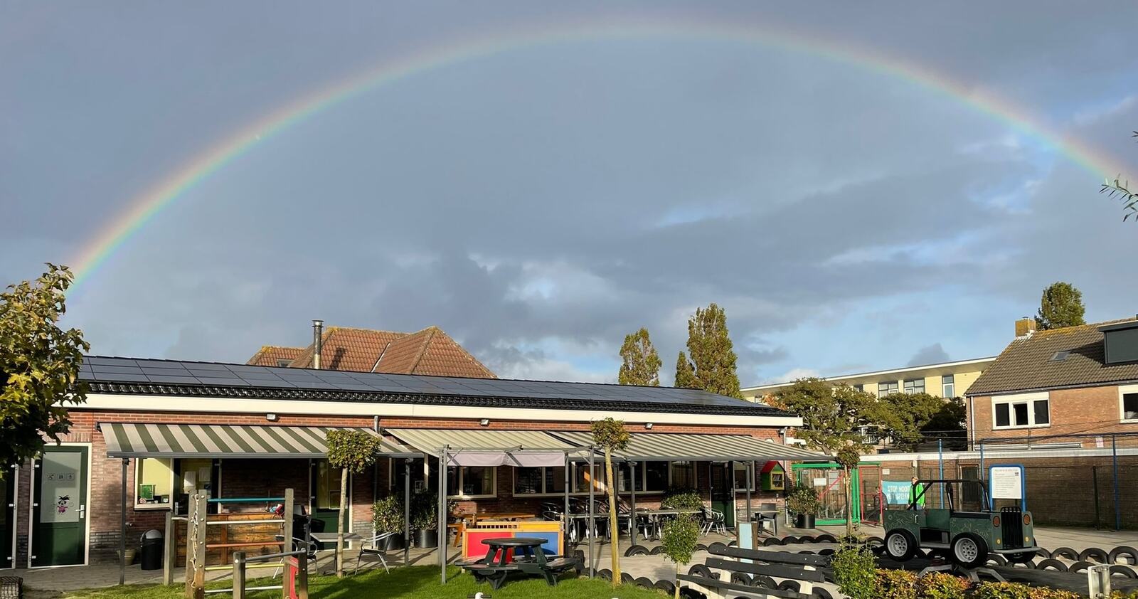 Regenboog boven de speeltuin
